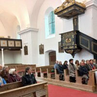 Reiseteilnehmer in den Sitzbänken der St. Veit Kirche
