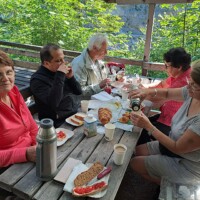 Pilgergruppe bei Pause mit Proviant bei Tisch